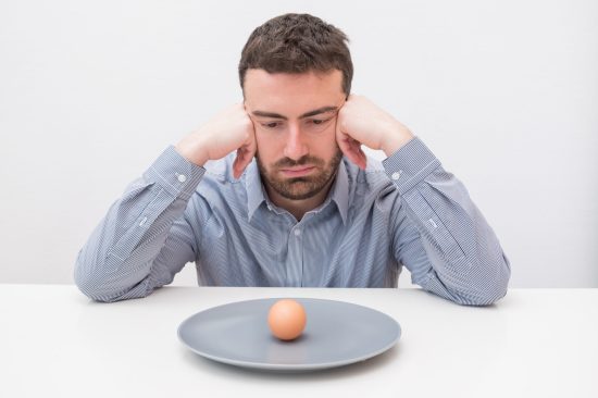 man-looking-at-egg-on-plate